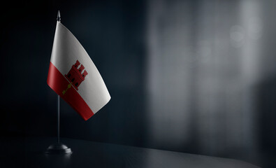 Small national flag of the Gibraltar on a black background