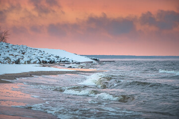 Frosty winter morning at Baltic sea shore in Riga. Beautiful landscape of seaside covered in snow and ice.