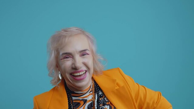 Funny grandmother old woman posing on colored background. Grandma influencer with fashionable clothes on stage, Concept about seniority and third age