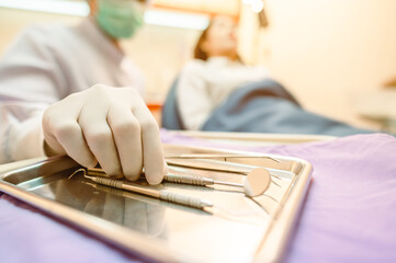 Dentist tools and equipment for dental care, consisting of dental checkers and mirrors, dentist for dental care in a metal tray on the table, purple background