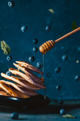 photo in levitation style with delicious pancakes and blueberries
