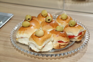 Pão de lanche com azeitonas e tomates.