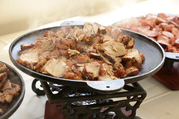 Pratos na mesa com carne na panela e salada lindas de ver.