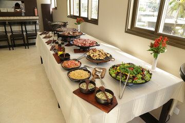 Pratos na mesa com carne na panela e salada lindas de ver.