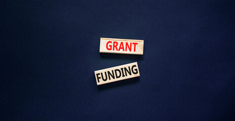 Grant funding symbol. Concept words Grant funding on wooden blocks. Beautiful black table black...