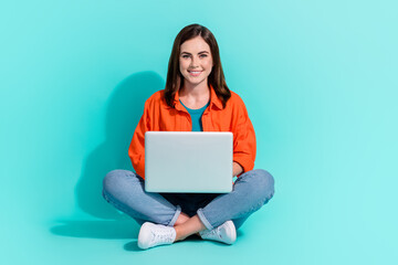 Full length photo of charming shiny girl dressed orange shirt chatting twitter telegram isolated turquoise color background