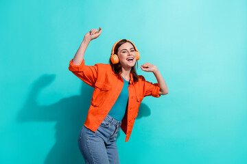 Photo of positive girlfriend wear stylish orange clothes chill vibe nice quality sound favorite hits isolated on cyan color background
