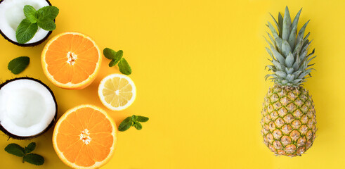 Pineapple, orange, lemon and coconut on the yellow background. Banner. Copy space.
