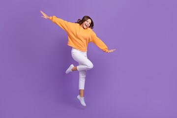 Full length portrait of cheerful excited girl jumping have fun empty space isolated on purple color...