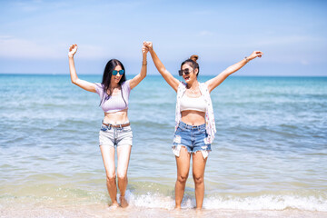 Couple LGBTQ girl on holiday happy running playing dancing along the beach on love emotion