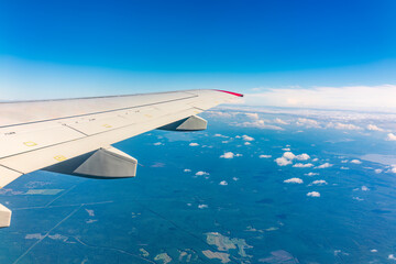 Obraz premium View from the airplane window at a beautiful cloudy sky and the airplane wing