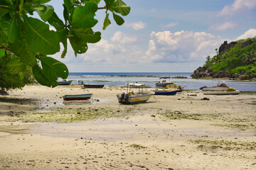 Mahe Seychelles, Port Glaud beach with very low tide, no water and boats are on the sand