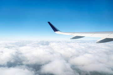 Obraz premium Wing of a plane in the sky during cloudy day