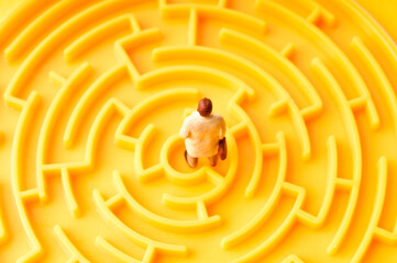 businessman figurine standing inside a maze