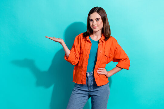 Photo of gorgeous lady wear stylish orange clothes arm demonstrate empty space seasonal sale low prices isolated on cyan color background