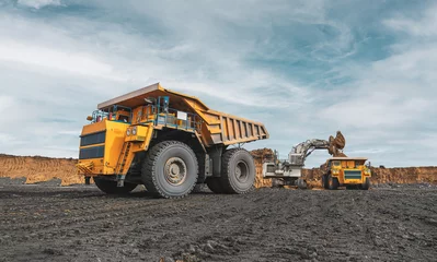 Fotobehang Vrachtwagen Large quarry dump truck. Big yellow mining truck at work site. Loading coal into body truck. Production useful minerals. Mining truck mining machinery to transport coal from open-pit production  © timofeev