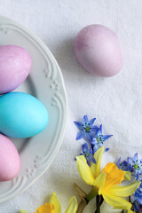 Easter background with colorful eggs and spring flowers on the table.