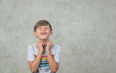 A cute little boy with autism in a studio setting frustrated with something against a green background with copy space