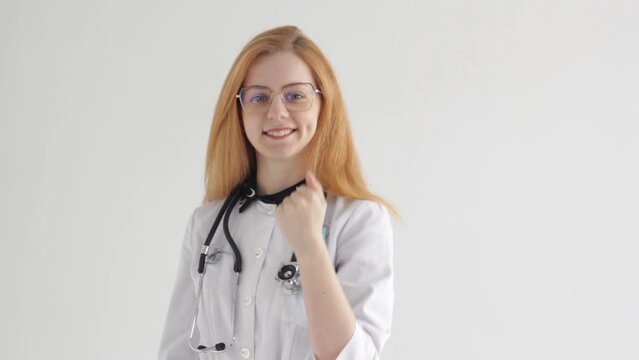 A young woman in a nurse's uniform presents and invites you to come with a hand on an isolated background.
