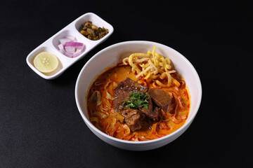 Khao Soi Thai Curry soup isolated in black background