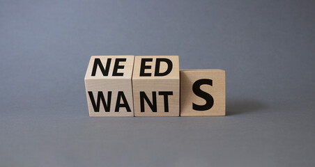Needs and Wants symbol. Wooden cubes with words Wants and Needs. Beautiful grey background. Business and Needs and Wants concept. Copy space