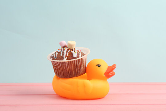 Rubber duck with Appetizing cupcake on a pastel background