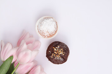 Cupcake with bouquet of tulips on white background. Top view