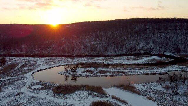 Aerial sunset dolly footage on river curve with scenic reflection in snowy winter. Siverskyi Donets river valley in Ukraine