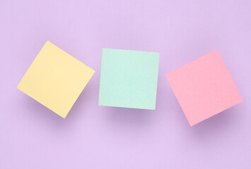 Empty Memo square sheets of paper on purple background