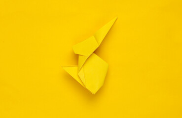 Yellow origami rabbit on yellow background