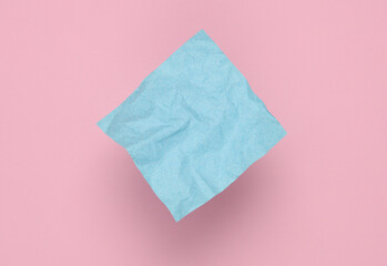 Crumpled square memo paper on pink background