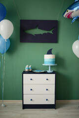 Home decoration of a children's holiday in the style of a shark, balloons and sweet pastries for children