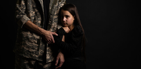 Masculine sad military man hugging her upset daughter indoors