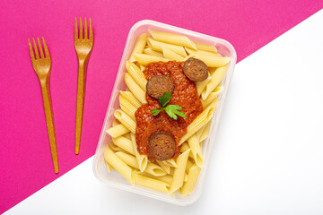 Macaroni with tomato sauce, chorizo and cheese in plastic container