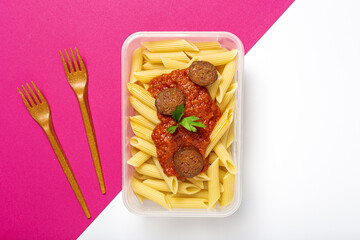Macaroni with tomato sauce, chorizo and cheese in plastic container