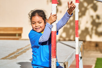 happy latin girl football player in a sport suit playing on a soccer goal
