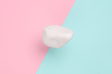 Soaring white pebble on pink background