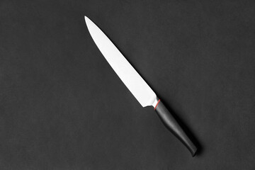 Large kitchen knife on a black background top view