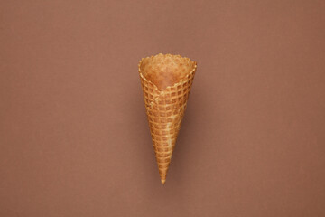 Empty waffle cone on brown background