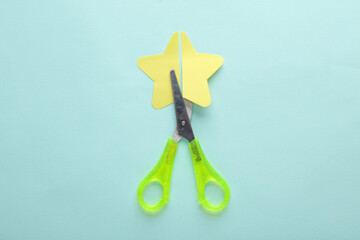 Scissors cut paper star on blue background