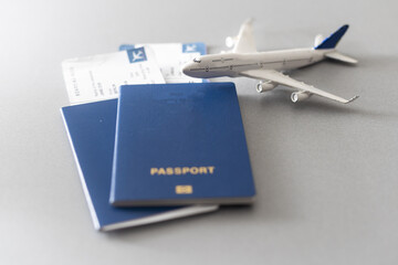 Passports, boarding passes and toy airplane on white table