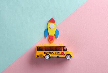 Toy school bus with rocket on pink blue background. Back to school. Education concept