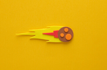 Toy handmade meteorite on a yellow background