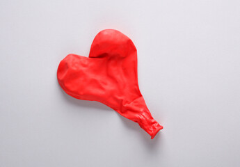 Red balloon in the shape of a heart on a gray background. Love concept