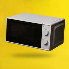 Fototapeta premium Wireless modern microwave oven levitating on yellow background with shadow