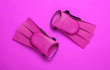 Children's pink fins on pink background. Top view