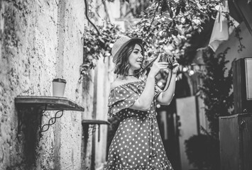 Young stylish woman in vintage clothes with a retro camera on old european street