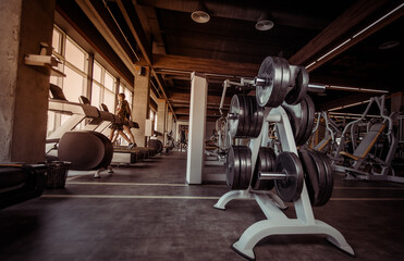 Interior of a modern gym. Rack with barbell discs