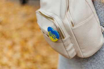 Ukrainian flag badge on a beige backpack
