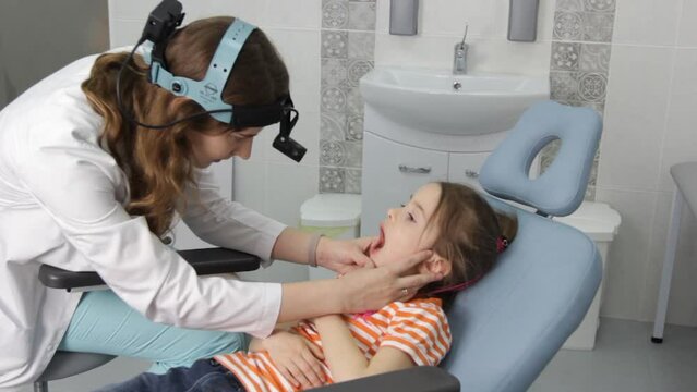 an otolaryngologist examines a little girl during a medical appointment.